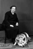 Ateljébild på en kvinna med hund. Enligt Walter Olsons journal är bilden beställd av fru N Johansson.
