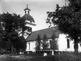 Valbo kyrka. 1933Valbo kyrka är Gästriklands äldsta kyrka. Genom den uppländske runristaren Åsmund Kåressons runstenar i östra Gästrikland att där fanns kristna i mitten av 1000-talet och att en kyrka i trä uppförts under 1000-talet. Området där kyrkan står heter Torsvallen platsen kan ha hyst ett tempel helgat åt asaguden Tor. Resterna av en stenkyrka, en absidkyrka återfinns under den nuvarande kyrkan, är från 1100-talet och daterades vid restaurering 1955-1956. Den nuvarande kyrkan började byggas är oklart. Enligt museiintendent O. Källström uppfördes den under 1300-talet senare hälft, medan docent B. I. Kihlström menar att kyrkan påbörjades i slutet av 1200-talet. Från denna period kvarstår koret och den östligaste delen av långhuset. Riksantikvarieämbetets register anger att långhuset är uppfört under perioden 1150–1199 och ut- och tillbyggt med kor under perioden 1270–1329. Förutom högaltaret hade kyrkan två sidoaltare, det södra helgat åt Johannes Döparen, till vars ära kyrkan invigts och det norra sannolikt till Maria. Under 1700-talet byggdes kyrkan ut med sakristia 1736, ytterligare ett valvkvarter 1742–1743 och ett torn 1776–1777, arkitekt Olof Tempelman till vilket kyrkklockorna flyttades från den tidigare fristående klockstapeln.
