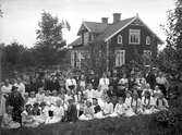 En och en halvvånings bostadshus med takhuv, glasad förstubro.
33 tyska krigsbarn med faddrar framför huset.
Anton Elving