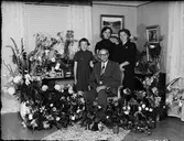 Familj omgiven av blommor i bostadsmiljö, Östhammar, Uppland