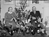 Rickard Kraft och kvinna omgiven av blommor i hemmet, Östhammar, Uppland