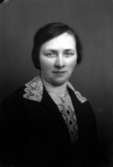 Ateljébild på en kvinna i halsband och klänning. Enligt Walter Olsons journal är bilden beställd av fröken Emma Rosén.