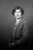 Ateljébild på en kvinna i halsband och klänning. Enligt Walter Olsons journal är bilden beställd av fru Eriksson.