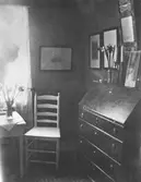 Interiör från stugan i Torstorp utanför Gränna. John Bauers siluett skymtar fram i fönstret.