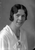 Ateljébild på en kvinna i halsband och klänning. Enligt Walter Olsons journal är bilden beställd av Alva Wallinder.