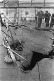 Ekensbergs varv 1970; varvsarbetare inspekterar skador på oidentifierat fartyg.