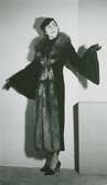 Modell i kappa med pälskrage och trumpetärmar, pumps och hatt, från Madame Vionnet.