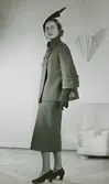 Höst/vintermode. Modell i dräkt, hatt, handskar och pumps av Jacques Fath.
