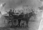 I vagnen sitter Johan Axel Hullander född 1863 i Strömsbro. Hullander utvandrade  på 1880-talet till  Melbourne, Australien och arbetade bl.a. vid gasverket i Mellbourne. Bilden förmodligen tagen i ateljé någonstans i Australien.