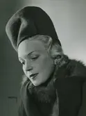 Modell i hög hatt, utan brätte. Pälskrage.
