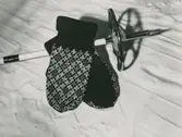 Ett par stickade vantar och en skidstav. Nordiska Kompaniet. text med blyerts på baksidan: 