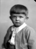 Ateljébild på en pojke i kofta. Enligt Walter Olsons journal är bilden beställd av herr Y Lindgren.