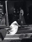 Bild på fyra damer varav en klappar en hund på verandan på Tuna gård.