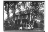 Skolbyggnad, 14 skolbarn.
Augusta Olsson.
