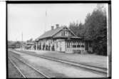 Hjortkvarns Järnvägsstation, envånings stationsbyggnad, åtta personer på plattformen.