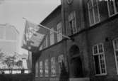 1940. Invigning av Trelleborgs flagga, flaggan upphängd ovan dörren till Rådhuset.