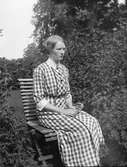 Kvinna sitter i trädgårdsstolen






