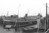 Ekensbergs varv 1970; oidentifierad pråm i lilla dockan, i bakgrunden skymtar bogserbåten GARPEN