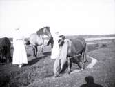 Två damer med några hästar i närheten av Tuna gård.