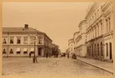 Drottninggatan österut, Stortorget till vänster och Enneska palatset vid Rådhustorget i fonden. Skyltar med texten 