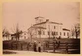 Vy från Åkaregatan mot Navigationsskolan. Byggnaden uppfördes 1862 och ritatdes av G.N. Runer. Skolan utbildade blivande sjökaptener och styrmän. Byggnaden, som Skepparsocieteten lämnat bidrag till, uppfördes i trä. Staden stod för virket. Ett så kallat observatorietorn, där eleverna fick lära sig ta ut solhöjd och göra olika beräkningar, uppfördes där. Idag ligger Polhemsskolan på platsen.