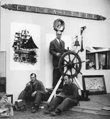 Sjöfartsutställningen 1957. Från utställningsarbetet: Dr Olle Källström vid Gerdas ratt samt två arbetare från Gävle varv.