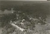 Flygfoto över Långemåla, Hornsö. Samhället Bebyggelse med bostäder och lantbruk, industri.
