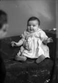Ateljébild på ett spädbarn. Enligt Walter Olsons journal är bilden beställd av fru A Kahl.