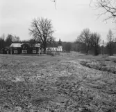 Ett trähus på vänster sida i Kulltorps kyrkby i Gnosjö kommun och längre bort ser man Kyrkan.