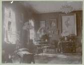 En salong i Sven Sundbergs hem med bland annat tavlor och en schäslong.