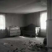 Storstugan i nedre våningen. Vardagsrum med soffa, kakelugn och byrå.