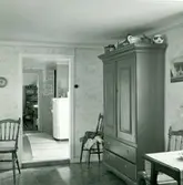 Rumsinteriör från en stuga i Sjöstorp, med skåp, kylskåp, stolar med mera.