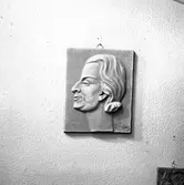 Foto av relief föreställande formgivare och keramiker Maggie Wibom. Självporträtt.