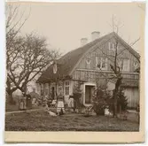 Krusenstiernska gården. Trädgårdsidan, snett från höger med människor i trädgården.