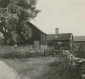 En gård med sadeltak och stenmur.