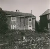 Förfallen tvåvånings enkelstuga. Troligen förhöjd med tanke på det låga vägglivet över de övre fönstren.