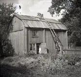 Byggnadens inre fasad med köksingången. Skorsten i kallmur.