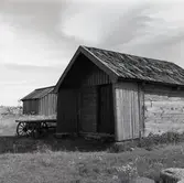 Sjöbod i skiftesverk med spåntak och svale.