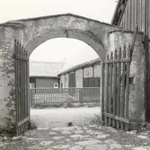 Porten sedd utåt. I fonden syns Södra Norrby 7:3.