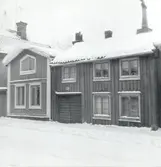 Bostadshus med träfasader och sadeltak i vintertid.