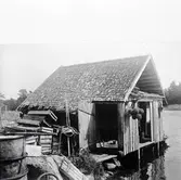 En fiskebod med spåntak och träfasad i Gammelnäs.