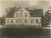 Den yngre huvudbyggningen, uppförd omkring 1850. Vitmålad. Å huvudfasaden en god empirportal med pilastrar och .. Målat i grönt och vitt.