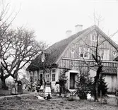 Krusenstiernska gården.
Huvudbyggnaden med folk utanför i trädgården.
Sett snett från höger.