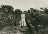 Lärarinnan Ida Danielsson i skolträdgården i Segerstad som hon själv skapat.
Material inlånat till trädgårdsutställningen 2001.