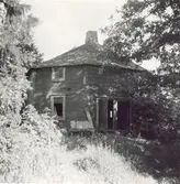 Ett bostadshus med tälttak och träfasad.