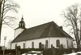Odensvi kyrka med kyrkogården i förgrunden.