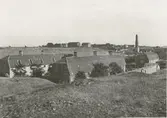 Arbetarebostäder vid norra ändan av bruksgatan.
Längst upp syns det gamla samt ett nytt magasin.
Bakom det senare skymtar den fram till landsväggen flyttade huvudbyggningen.