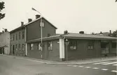 Byggnadsinventering juni 1974, bostadshus med fasad mot Fiskaregatan - Proviantgatan. Den låga byggnaden har varit bensinstation, senare riven. På platsen byggdes bostadshus. Bilderna är tagna inom ramen för Kalmar kommuns inventering av Kvarnholmens bebyggelse 1974 och skänkta till länsmuseet.