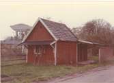 Ekonomibyggnad i Berga, Kalmar, med vattentornet i bakgrunden. Har möjligen varit en hållplats för tåg. Bilderna är tagna inom ramen för Kalmar kommuns inventering av stadens bebyggelse 1974 och skänkta till länsmuseet.
