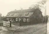 Huvudbyggnaden sedd från landsvägen. Tegel i övre tackfacket, bräder i undre.